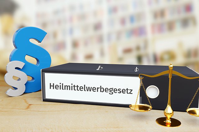 Heilmittelwerbegesetz – Recht/Gesetz. Ordner auf Schreibtisch mit Beschriftung neben Paragraf und Waage.